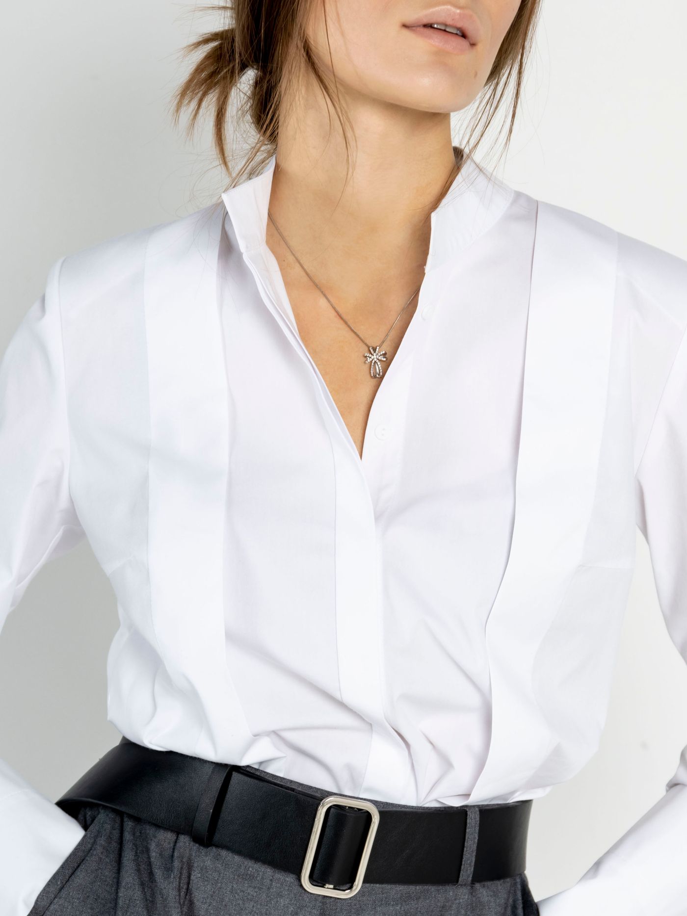 White button-up shirt tucked into dark trousers with a black belt.