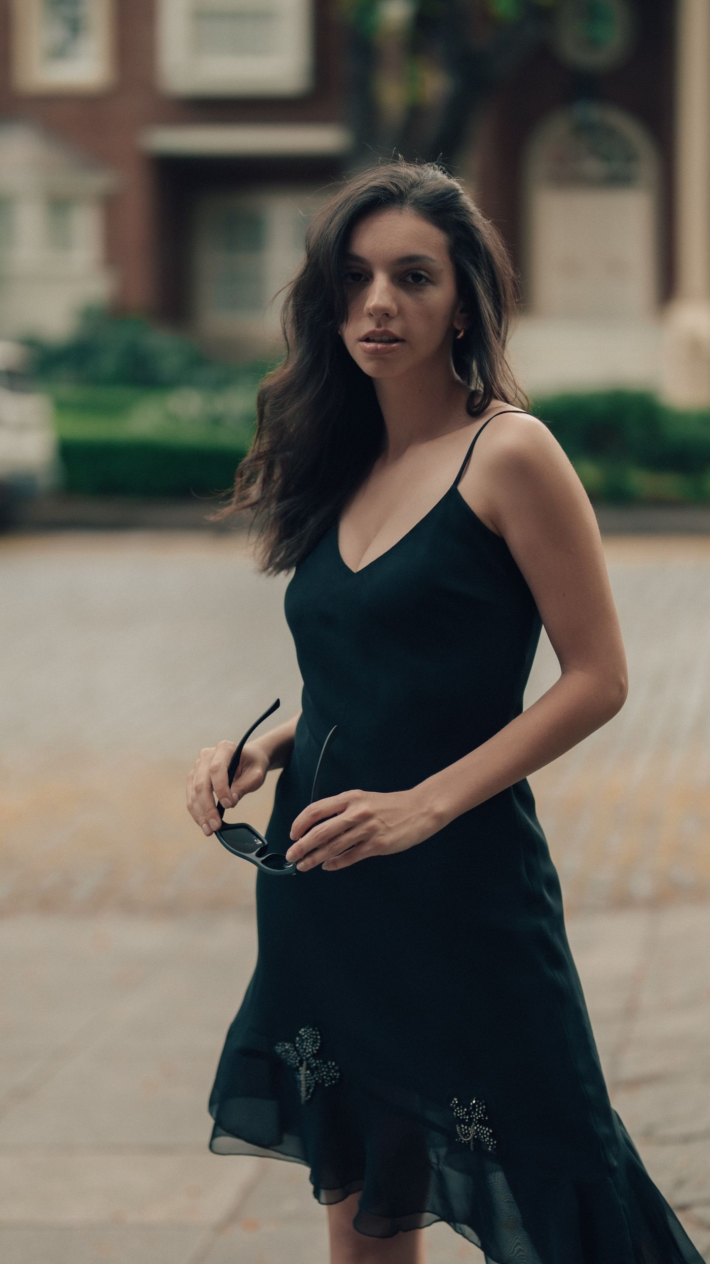 Woman wearing a plain black dress outdoors in daylight.