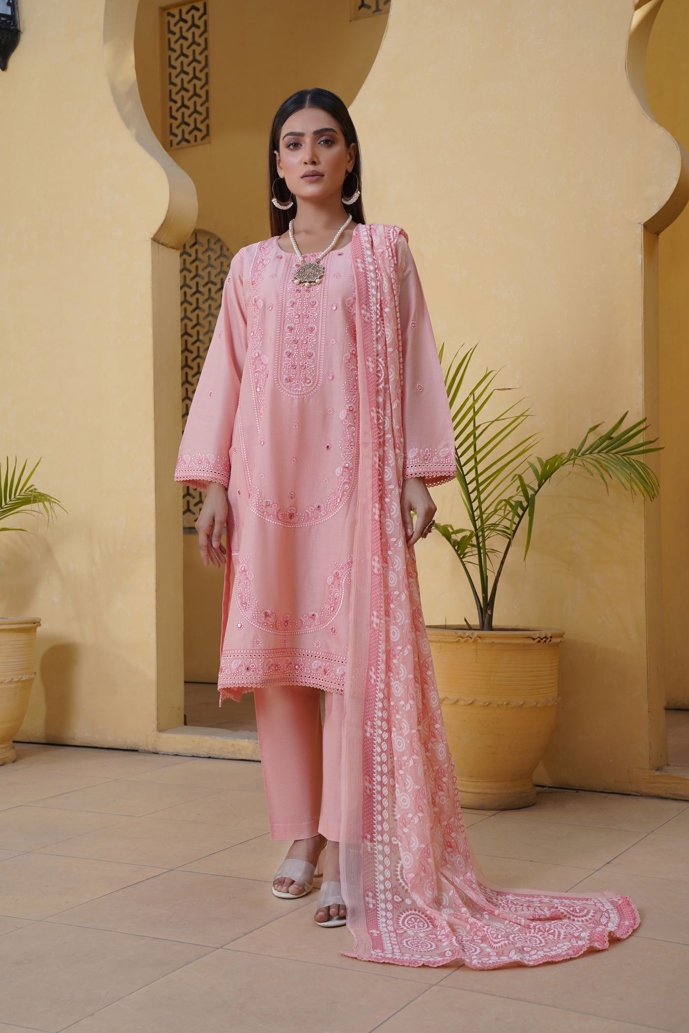 Woman wearing a pink long tunic with matching cropped trousers.