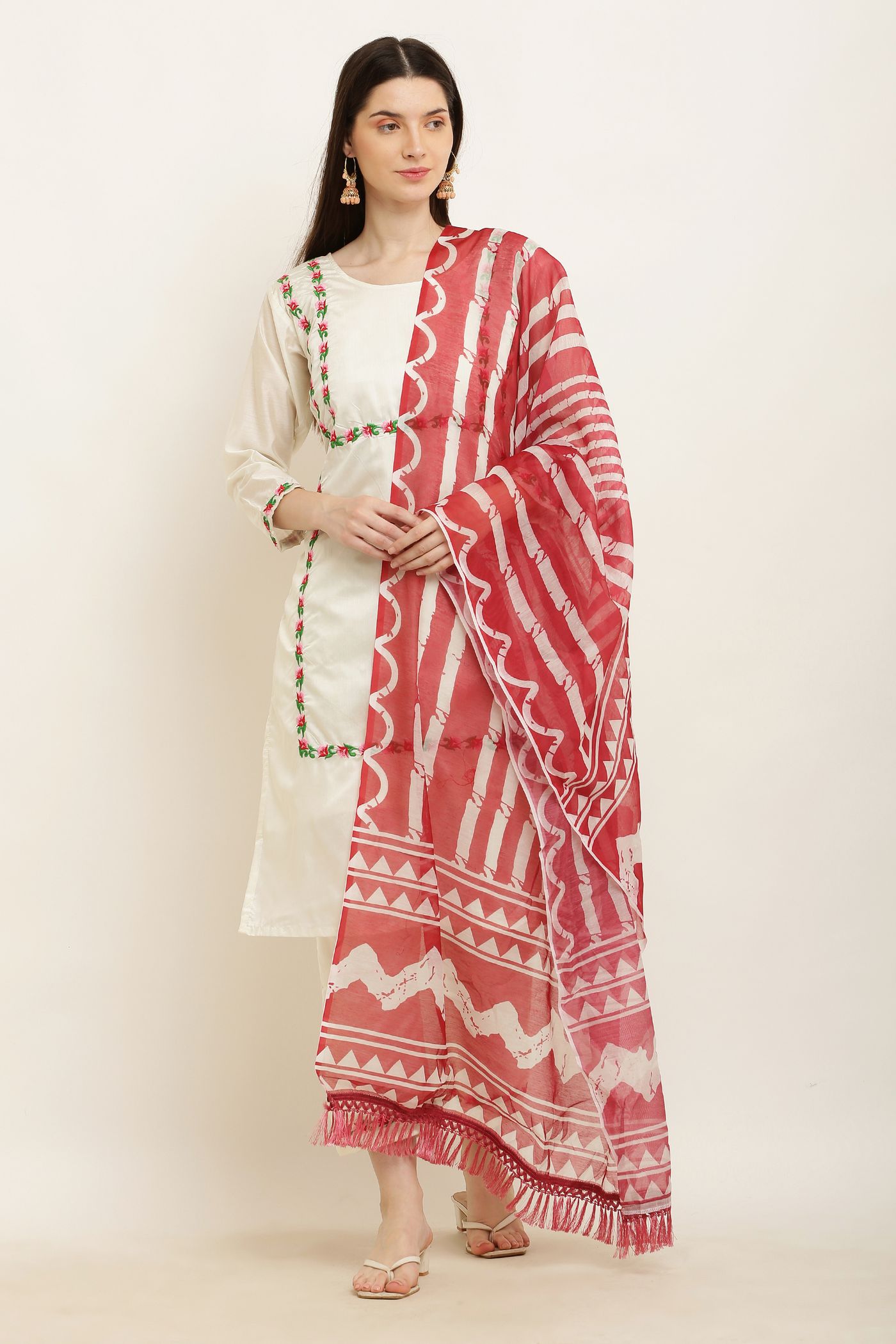 Woman in a plain cream kurta set with a large red patterned dupatta.