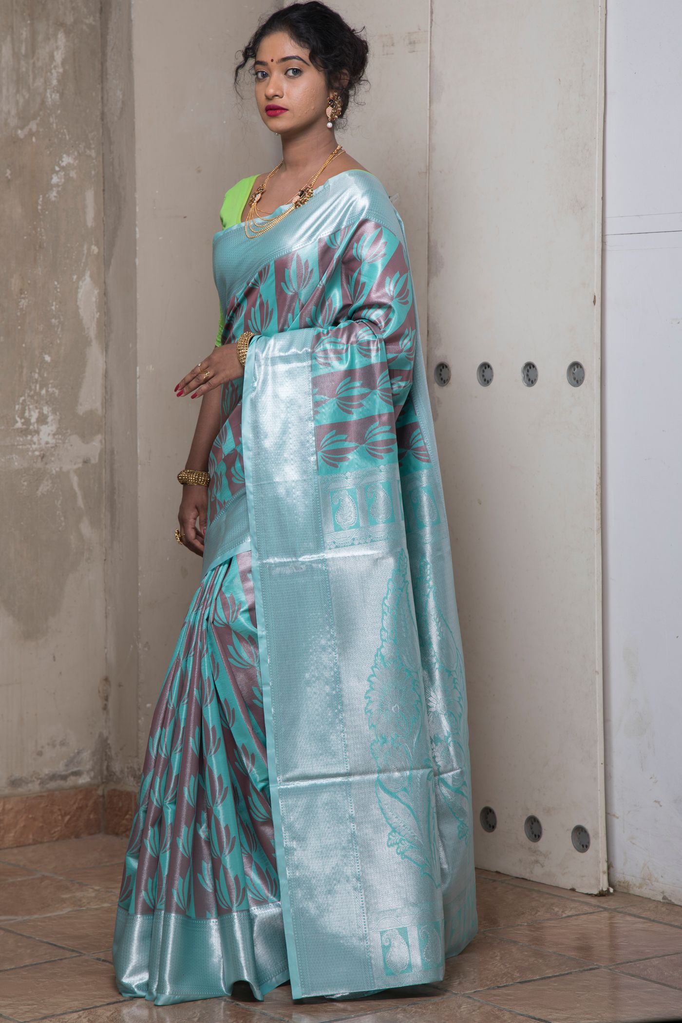Woman wearing a lustrous pale green saree with a simple matching blouse.
