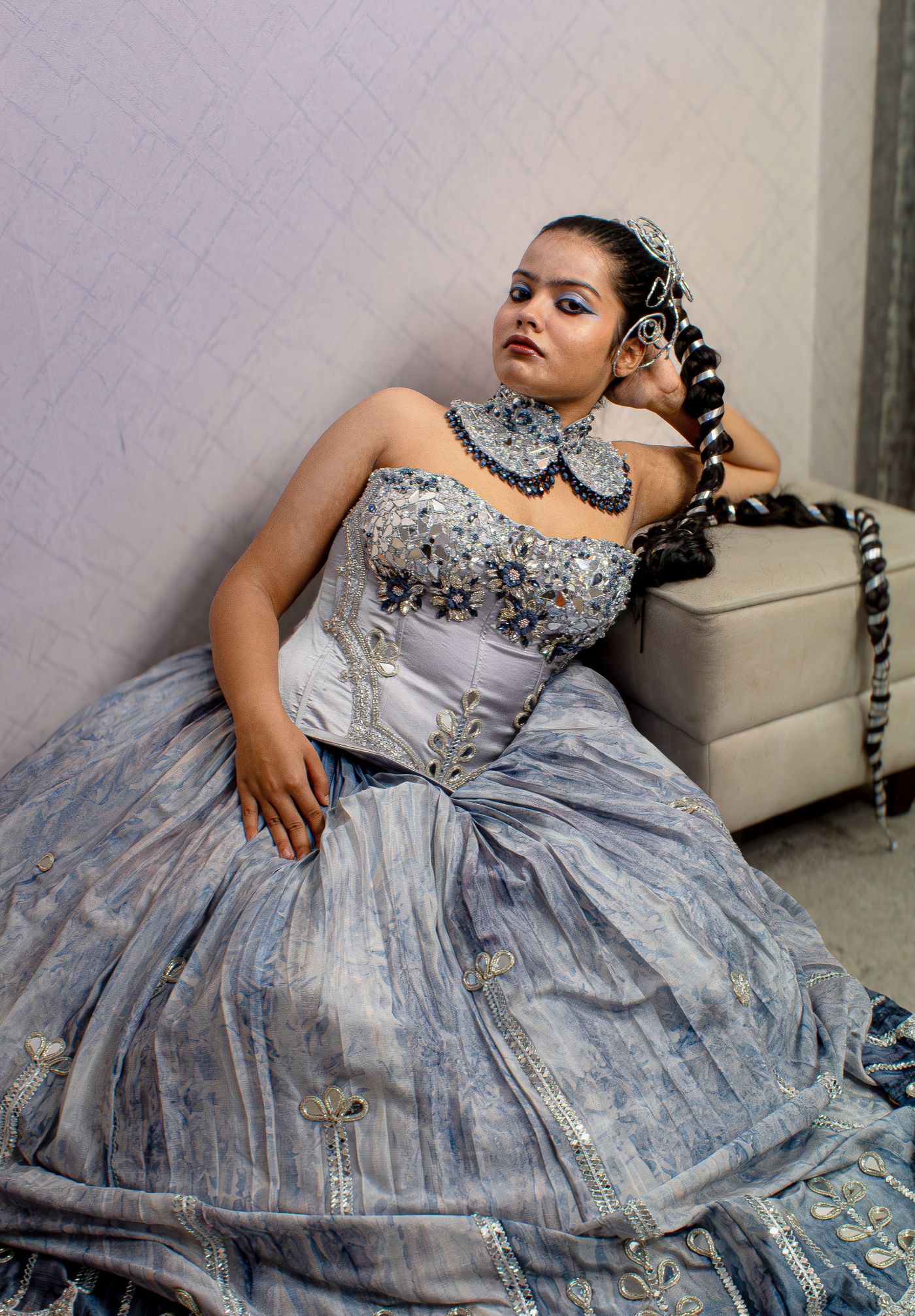 Woman wearing a grey embroidered lehenga and sleeveless embellished blouse.