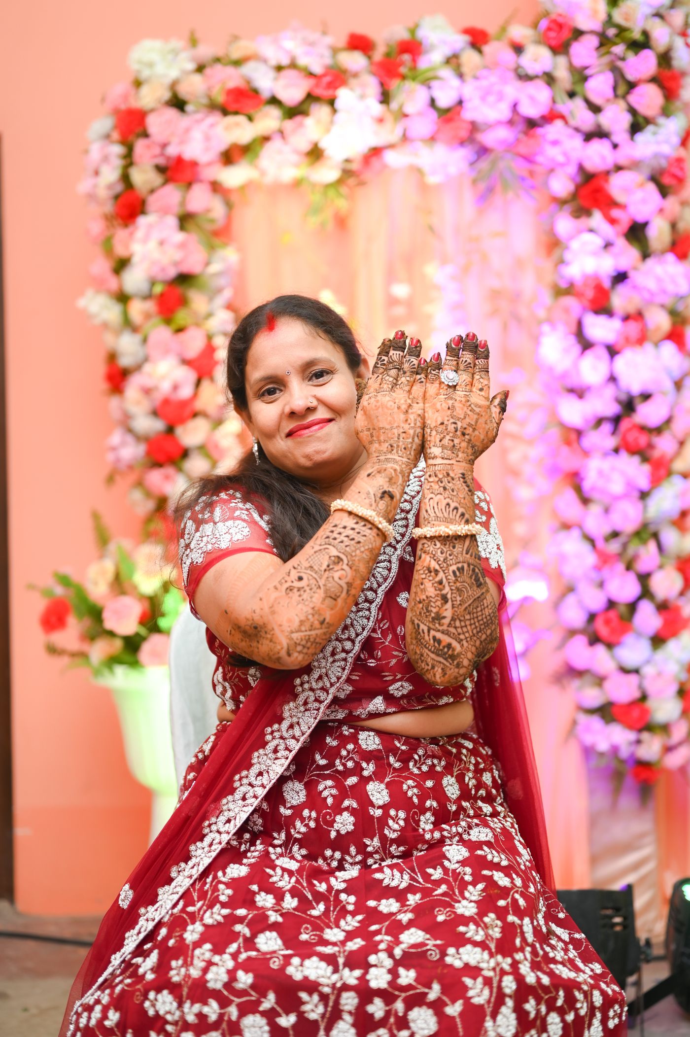 Woman dancing in a red and white festive outfit at a celebration.